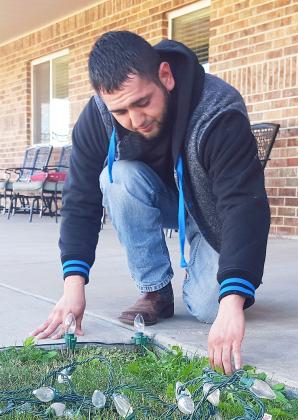 Mario Ortega placed Christmas lights along the sidewalks at Good Life Assisted Living on Tuesday.