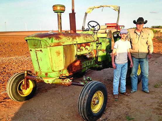 Austin Reynolds (left), with family friend Rick Williams, is restoring Williams’ 1969 John Deere 4020 Diesel tractor for his Future Farmers of America agriculture mechanics project.