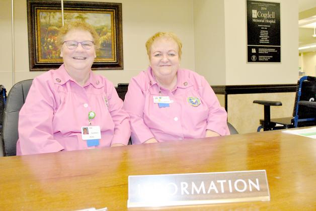 Today, Auxiliary members Alana McRoberts (left) and Mary Pownell help patients and family members find their way around the hospital. The Auxiliary will celebrate its 60th anniversary during a community reception on Sept. 17.