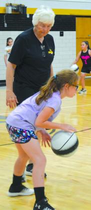 Snyder High School coach Jan Kruse (left) helped Paityn Fine with proper form while dribbling the ball down the court during the Lady Tiger Basketball Camp.