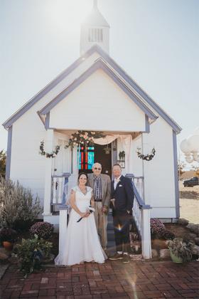 Shelley Pendergrass (l-r), her grandfather, Bernhard Bartels and groom Carl Pendergrass stand in front of the chapel that Bartels built in 2011.