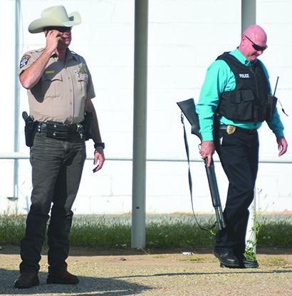 Scurry County Chief Deputy Brian Martinez (left) received information via phone and Snyder police Sgt. Kyle Burleson prepared to enter the 888 Game Room on Coliseum Drive during an investigation into an armed robbery at the game room Tuesday afternoon.