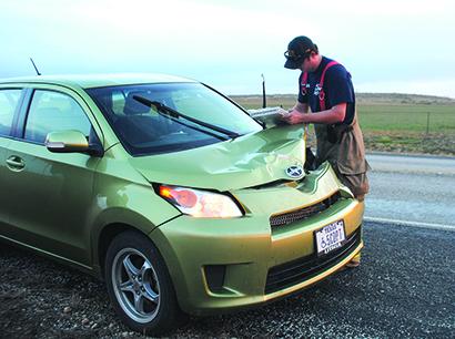 SDN Photo/Glen Brockenbush Snyder firefighter Nathan Evans writes an accident report after a vehicle hit a deer on South Hwy. 208 at 7:15 a.m. today. No medical transport was needed.