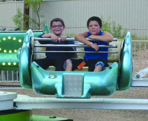 Tyler Minton (left) and Dakota Pidwell rode a carnival ride during the Pride of Texas Carnival at Towle Park Friday night.