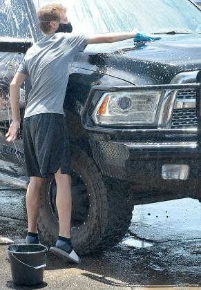 nyder senior Cayden Hurtado wiped down a truck during the Snyder soccer programs’ car wash fundraiser in the Prosperity Bank parking lot Friday. Hurtado plays football and soccer.