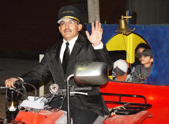 Joe Martinez was the conductor of the Polar Express in downtown Snyder Monday during the Christmas in the Park event, hosted by Snyder ISD Afterschool Centers on Education. Pictured riding in the first car, is Jonah Castillo.