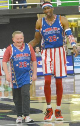 Scurry County resident Collin Maxfield (left) walked down the court with Globetrotter Hi-Lite Bruton. Maxfield was given a jersey after making a free throw blindfolded.