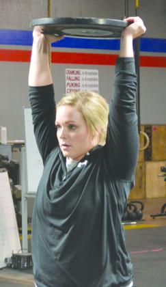 Megan Conner held a weight above her head during a team workout.