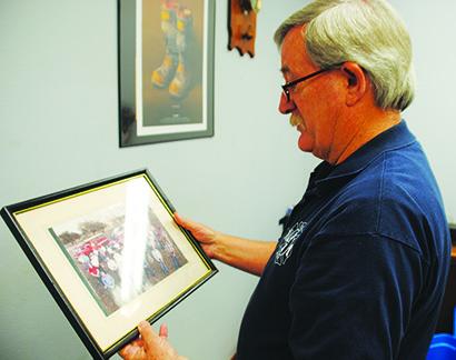 Retiring Snyder Fire Marshal Cy Posey looks at a picture of the 1993 Snyder Fire Department as he cleans up his office earlier this month.