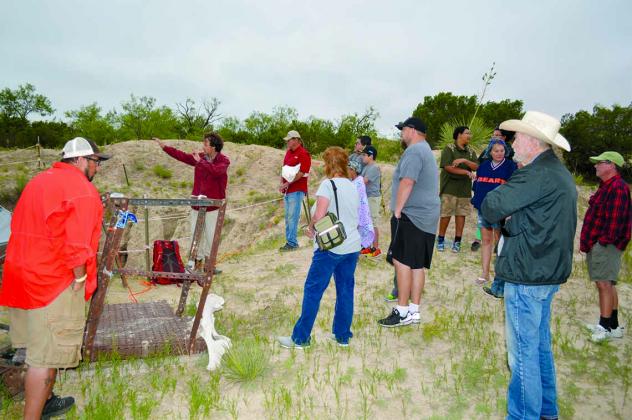 Texas Tech University graduate student John Moretti (second from left) discussed the history behind the stream deposit at the Roland Springs Ranch paleontology dig site on Saturday.