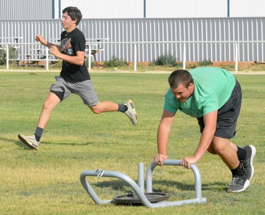 Bryton Partain (left) ran sprints while junior Drew Porter pushed a sled during summer workouts at Bulldog Field Monday. Both Partain and Porter figure to be members of the varsity squad in 2020.