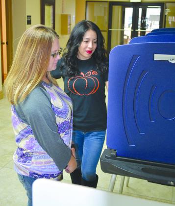 Brandy Benavides (left) and Selene Gallegos inspected voting machines at the Scurry County Courthouse Friday morning. Early voting for the Nov. 7 constitutional amendment election begins Monday on the first floor of the courthouse.