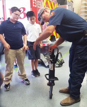 Snyder Fire Department Lt. Ben Poe showed Snyder Christian School students (l-r) Trintyn Hastey and Kevin Nguyen how a hydraulic rescue tool works during a tour Wednesday.