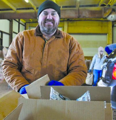 Snyder Kiwanis Club member Matt Lowry distributed beans and rice to recipients during Saturday's Goodfellows Food Drive give-away at The Coliseum annex.