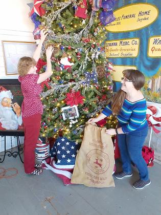 Gayle Summers (left) and Nancy Phillips of the Snyder Community Beautification Association decorated a Christmas tree in the Dermott School at Heritage Village Friday afternoon.