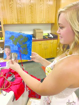 Hermleigh High School senior Morgan Digby takes one final look at her Fresh Prince of Bel Air-inspired mortar board prior to Friday’s graduation ceremony.