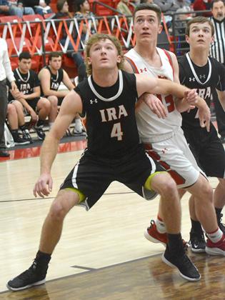 Hermleigh senior Kobe Roemisch (center) battles for a rebound with Ira senior Karson Valentine (left) and sophomore Ike Weaver during the Cardinals’ 42-40 win over the Bulldogs Friday. Roemisch scored the last second layup that lifted the Cardinals over the Bulldogs.