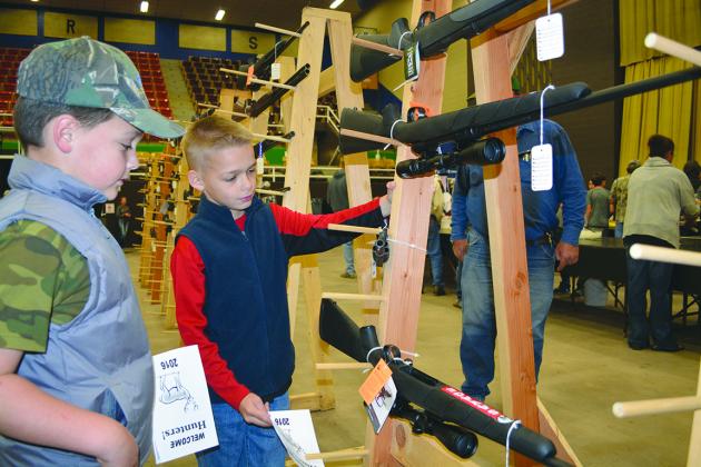 Colton Moffett (left) and Xander Moffett of Shallowater, the grandsons of Snyder’s Pat Brown, looked at some of the rifles that were on display during Friday’s hunter’s appreciation dinner at The Coliseum.