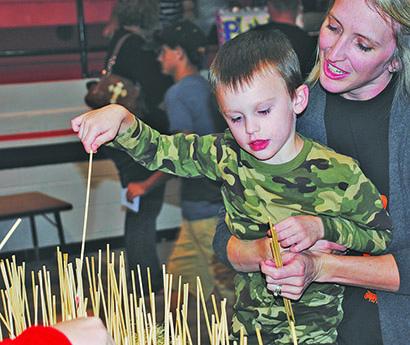 Daniel Rosson, 4, played a game with the help of his mother, Meagan, at the Ira ISD  fall festival Friday night. 