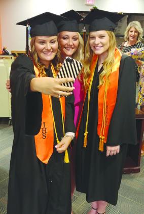 Ira High School graduates (l-r) Abby Manning, Lesli Whetsel and Alyssa Goodwin take a selfie prior to the beginning of commencement exercises at the school Friday.