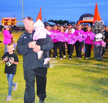 Ira head football coach Toby Goodwin carried 21-month-old Mariaha Shearer onto the field before Friday’s game against Hermleigh. Shearer was diagnosed with Anaplastic Ependymoma, a rare brain/spinal cord tumor, three months ago. She has been at MD Anderson in Houston the past three months receiving treatment. She was able to come home last week to rest, but will return to Houston for treatment on Oct. 16. Friday’s Pink Out game featured program sales, a bake sale and chicken spaghetti meal to raise money fo