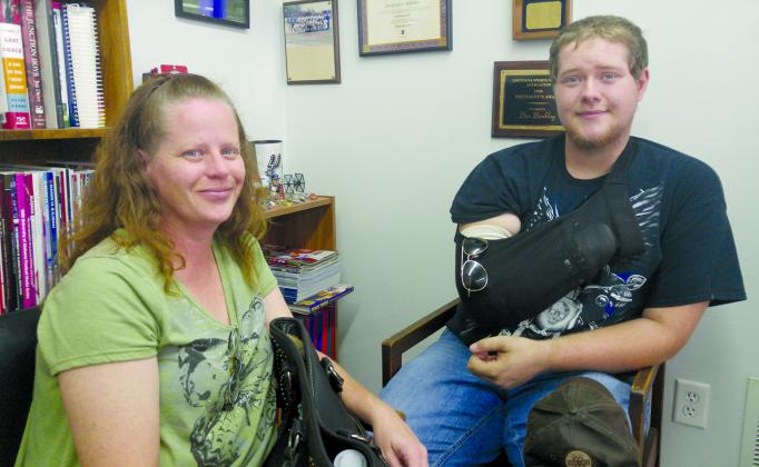 Snyder High School senior John Gilbert (right) lost his hand in a March 7 motor vehicle accident. Also shown is his mother, Becky.