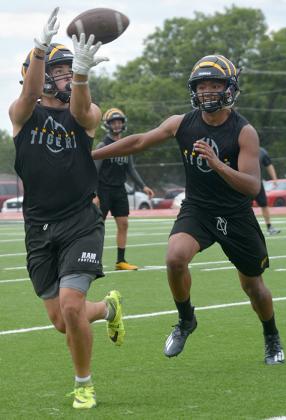nyder senior  wide receiver Jordan Savage (left) reeled in a pass as junior line backer Chris Sifuentes pursued. The Tigers enter year two under head coach Wes Wood.