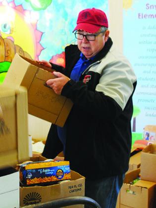 Larry McAden loaded food onto a dolly at Snyder Elementary School for the Kiwanis Club’s Goodfellows food drive. McAden said the club struggled filling baskets due to a lack of monetary donations. 