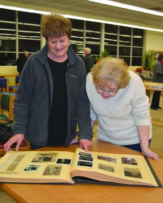 Caroline Martin (left) and Sandy Norris looked through old photo albums during the Scurry County Library’s 60-year celebration program Jan. 18.