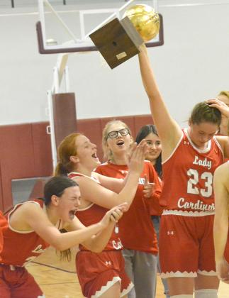 Hermleigh players (l-r) Brittany Smith, Sarah Murphy and Rachaelle Smith celebrated as Makia Gonzales hoisted the trophy following the Lady Cardinals’ 43-31 win over Guthrie in the regional quarterfinals Monday. The Lady Cardinals will open play in the Regional Tournament at Abilene Christian University at 8:30 p.m. Friday.