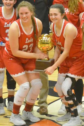 2020 Hermleigh graduates Makia Gonzales (left) and Ryleigh Benitez held the District 13-1A championship trophy. Benitez and Gonzales were the only two seniors on the 2020 Lady Cardinal team.