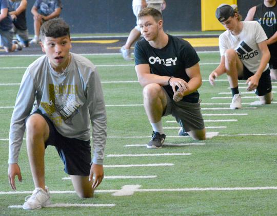 Snyder High School senior Martin Castellon, junior Kyler Teakell and sophomore Dylan Angeley stretch before a morning workout in the Snyder indoor complex earlier this summer. The UIL released new guidelines for summer workouts that mandate all athletes and coaches wear face masks and allow athletes access to the locker rooms.