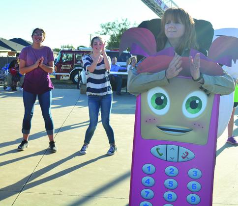 Pictured dancing are (l-r) Bonnie Jasper, Madelyn Alexander and Scurry County Sheriff’s Deputy Jeanette Pritchard, dressed as Cell Phone Sally, during Tuesday’s National Night Out.
