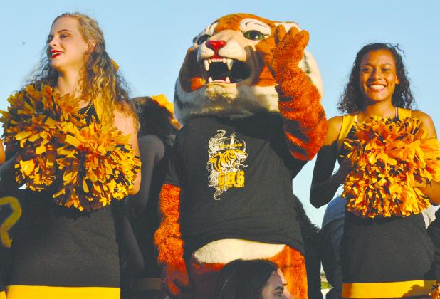 Snyder High School varsity cheerleaders (l-r) Tegan Dickson, Victory the Tiger and Madelyn Cravens led cheers on the varsity football team trailer during the annual homecoming parade Monday.