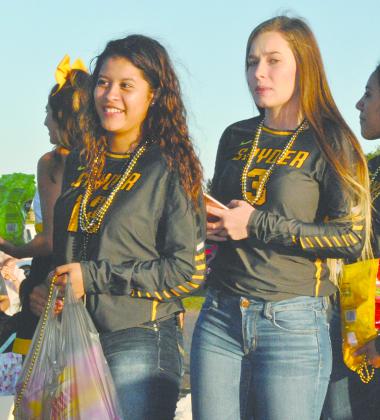 Snyder JV volleyball team members Daija Torres (left) and Paige Steelman threw candy to the crowd during the annual homecoming parade Monday.