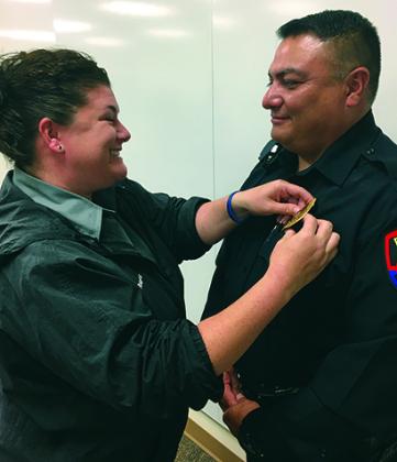 Gilbert Ramos (right) was promoted to corporal at the Snyder Police Department Tuesday. His wife, Amy, pinned his badge on his uniform.