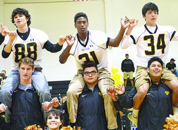 Snyder High School football players (l-r) Shawl Lentz, on the shoulders of Zane Vandygriff, J.J. Burns, on the shoulders of Alex Jaimes, and Jayden Samaniego, on the shoulders of Diego Lopez, sing the alma mater with cheerleader Madison Curry during today’s pep rally. Snyder will play at Big Spring today in the District 3-4A  Division I football opener. Kickoff is set for 7:30 p.m.