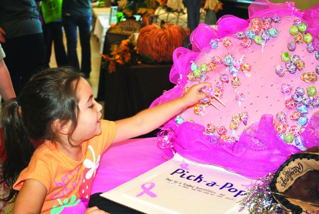 Four-year-old Klarissa Lopez picked a sucker at the Kindred at Home booth at Saturday’s Cogdell Memorial Hospital health fair. Each sucker was color-coded for a prize. More than 35 organizations had information available at the fair, which also included the annual Pink Run and Walk.