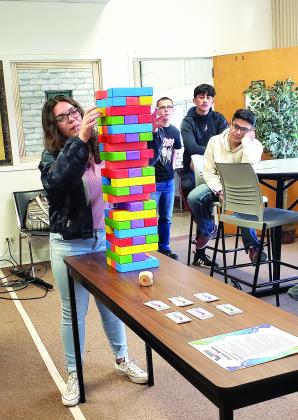 Students in Snyder High School’s Pathways in Technology Early College High School (PTECH) program played an oversized game of Jenga Friday as a focus for a discussion on careers. Pictured here, Larrisa Wilkinson pulls a Jenga piece as  Shad Hodge, Damien Jimenez and David Santos look on. 