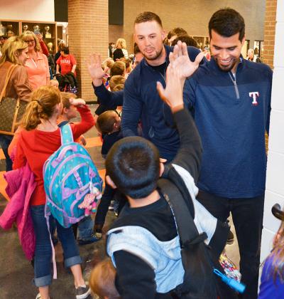 Texas Rangers Andrew Faulkner (left) and Robinson Chirinos joined members of the Ira High School baseball and softball teams to greet elementary students following Friday’s pep rally. The Rangers Foundation presented a $3,000 check to the baseball program during the pep rally.