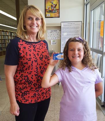 Eight-year-old Raelee Leatherwood, of Snyder, collected a coupon for free ice cream from Scurry County Library Children’s Librarian Lisa Hartzog on Tuesday after completing three hours of reading time.