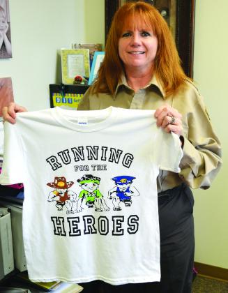 Scurry County Sheriff’s Deputy Jeanette Pritchard holds a T-shirts for this year’s Running for the Heroes 5K run, which will be held Saturday in Towle Park. The 5K will begin at 9 a.m.