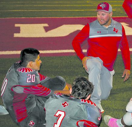 Hermleigh head coach Sam Winters (right) spoke to players Patrick Carr (20) and Jase Ellison during halftime of the Cardinals’ 59-20 win over Bronte at Cardinal Stadium Friday.
