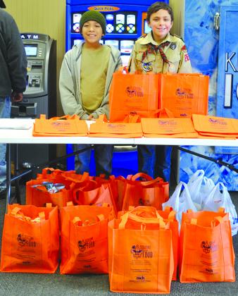 Cub Scouts Avian Torres (left) and Conner Reese were among the Snyder Scouts who helped collect food for the Scurry County Food Cupboard on Saturday at United Supermarket.