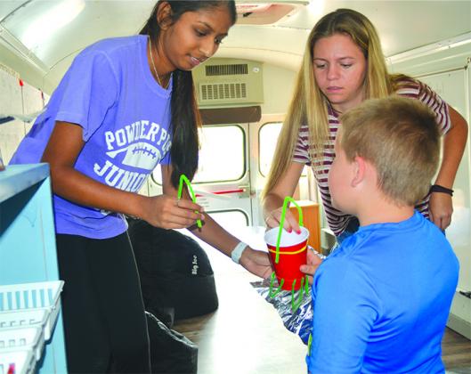 Incoming Snyder High School seniors Meera Bhakta and Jesi Hunter helped Treydan Bowlin create a space model Monday during the STREAM mobile learning center’s first public lesson.