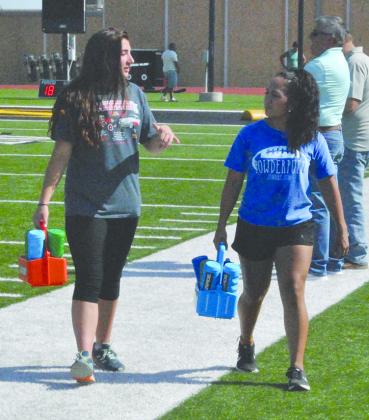 Bonnie Jasper and Cheyenne Avila return to the sidelines after providing water to the players.