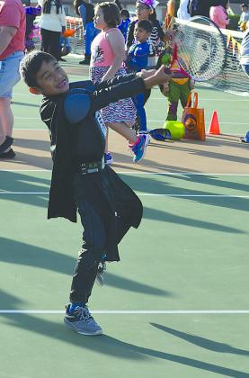 Xaden Hernandez hit a tennis ball to win candy during Carnival at the Courts Saturday.