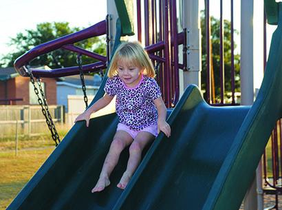Emie Garner, 3, goes down the slide at the playground at Towle Park today. Summer temperatures are in the forecast through Thursday with highs in the mid 90s. 