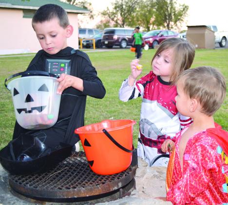 Ace Block (from left), 6, Mason Block, 4, and Eli Block, 2, review the candy they received at White Boo-ffalo Halloween at Towle Park on Saturday.