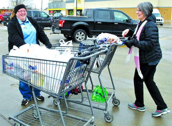 United Supermarket team member Denise McCauley (left) braved the cold weather and helped Bridgette Green (right) bring groceries to her car.